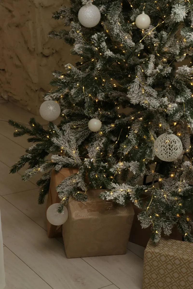 Árbol de Navidad con luces y regalos envueltos en papel kraft (foto de ambiente)